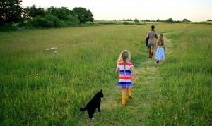 Two of the Tribe plus one cat walking a guest to the top of the field